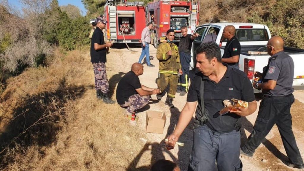 Israeli and Palestinian Authority firefighters on a lunch break while battling wildfires outside Jerusalem on Aug. 17. (Israeli Ministry of Foreign Affairs/Facebook)